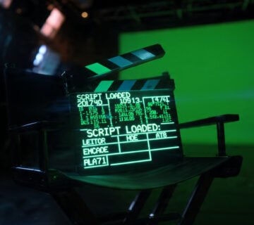 Claqueta de cine digital brillante mostrando código y el texto Veo 3 1 en un estudio de grabación oscuro